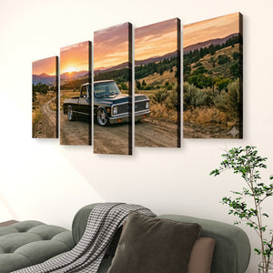 A five-panel canvas wall art set depicting a vintage pickup 1970 Chevy C10 Fleetside truck on a dirt road at sunset, displayed on a white wall above a green sofa in a living room setting.