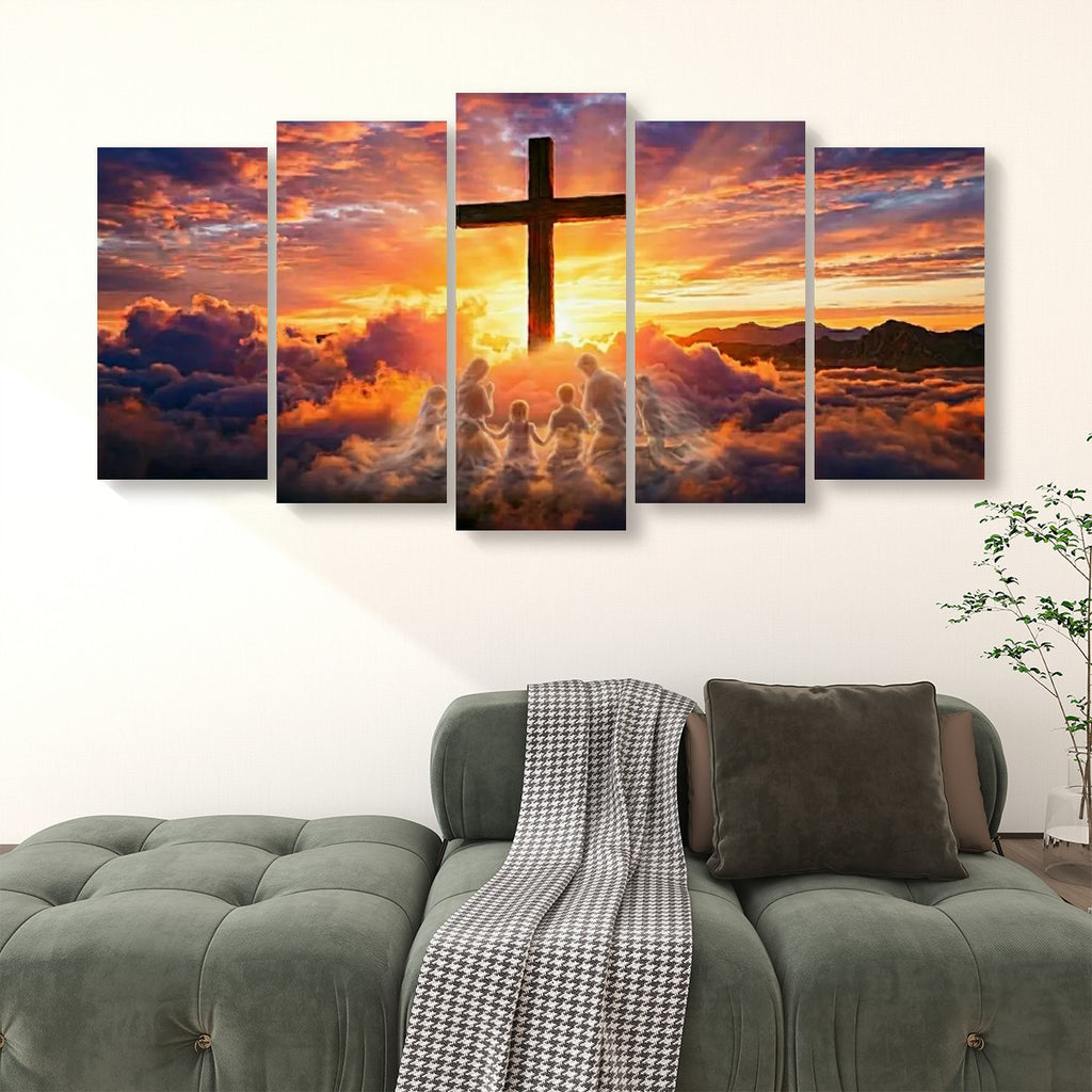 A 5-panel canvas wall art set depicting a dramatic sunset sky with a large cross, clouds, and silhouetted figures, displayed above a green sofa in a living room setting.
