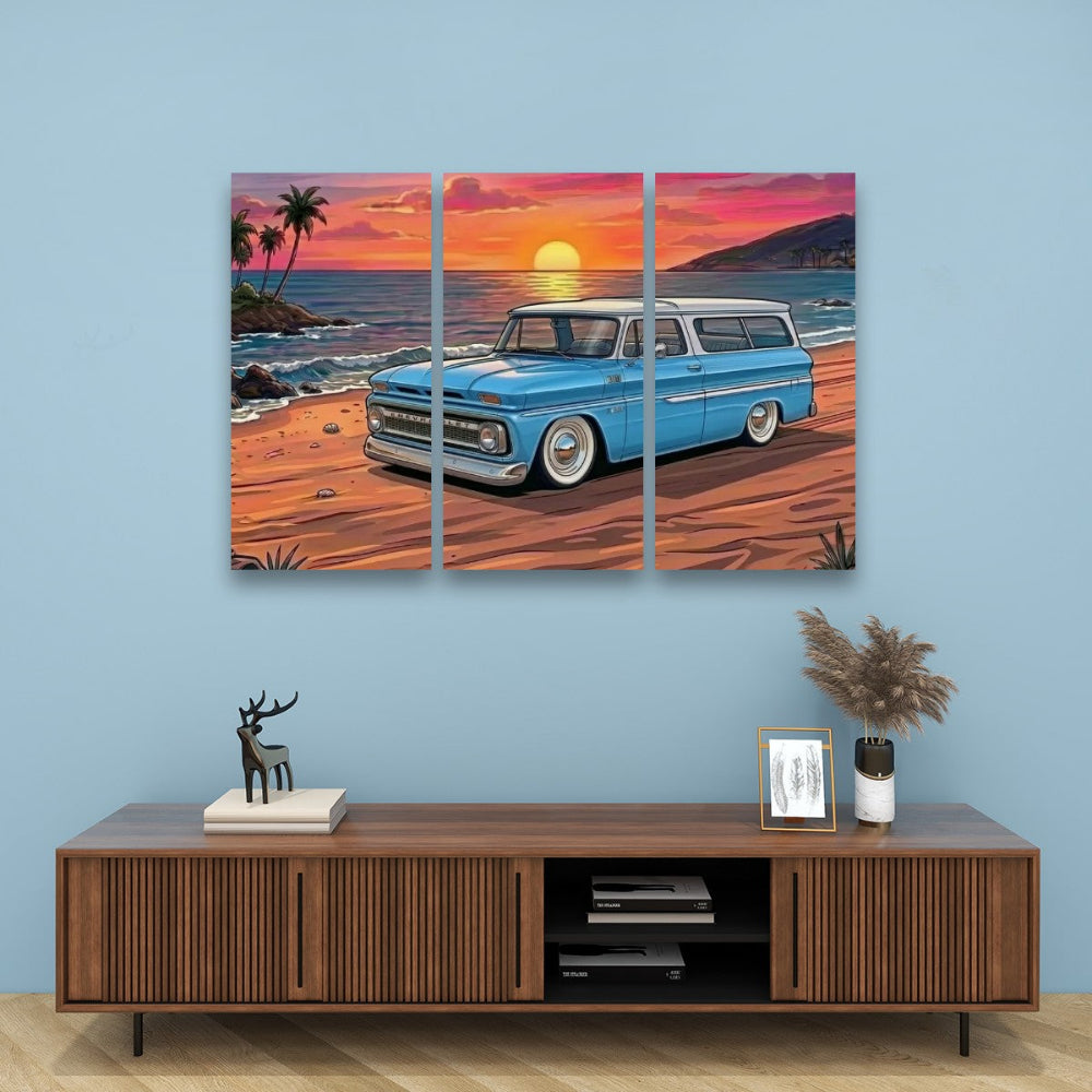 A three-panel canvas wall art print depicting a 1966 Chevy Suburban on a beach at sunset, displayed above a wooden console table in a modern living room setting 1966 Chevy Suburban