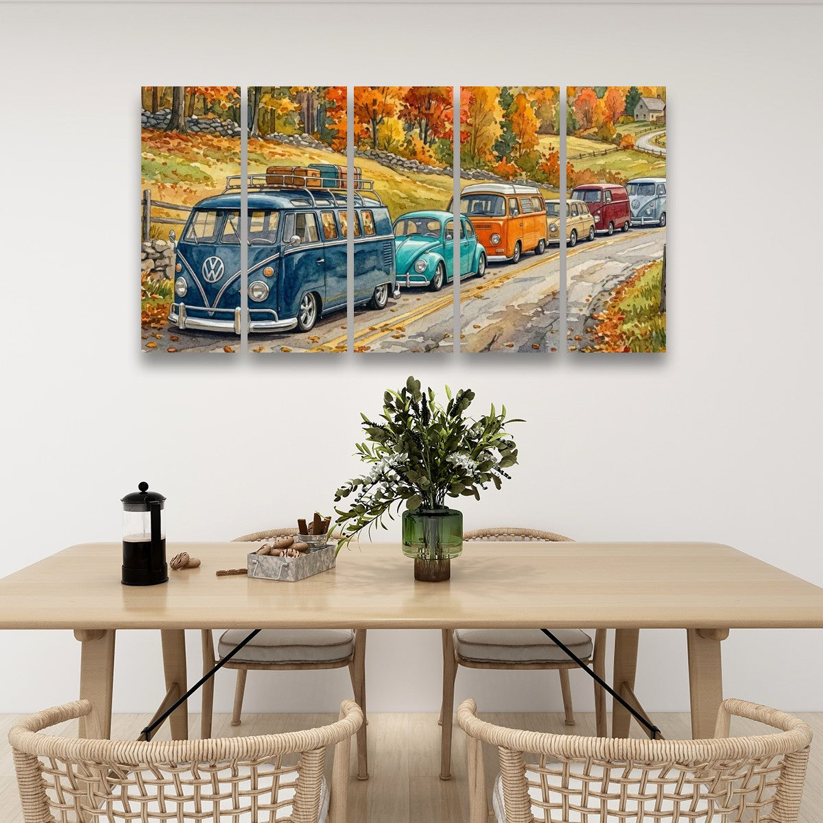 A five-panel canvas wall art print depicting a colorful autumn road scene with vintage VW buses and cars, displayed on a white wall above a wooden dining table with chairs.
