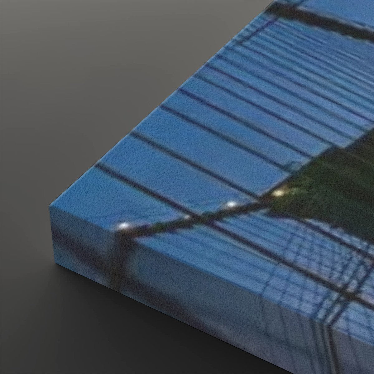 A rectangular canvas or print showing an abstract blue-toned architectural or grid-like scene, photographed at an angle on a dark gray background.