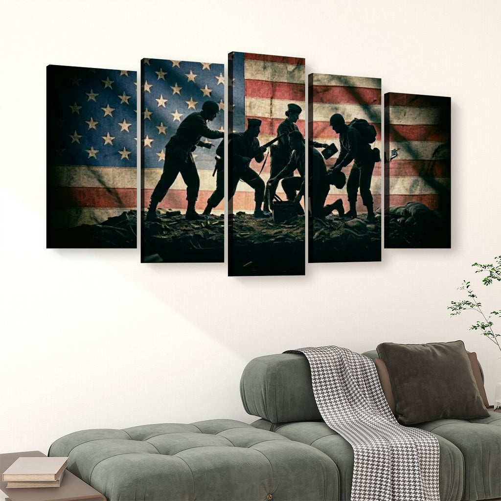 A five-panel canvas wall art set depicting silhouetted soldiers raising a fallen comrade against a distressed American flag, displayed above a green sofa in a living room setting.