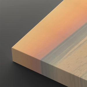 A close-up of a rectangular block or sample with a smooth color gradient transitioning from peach-orange at the top to pale beige and light gray on the sides, set against a dark gray background.