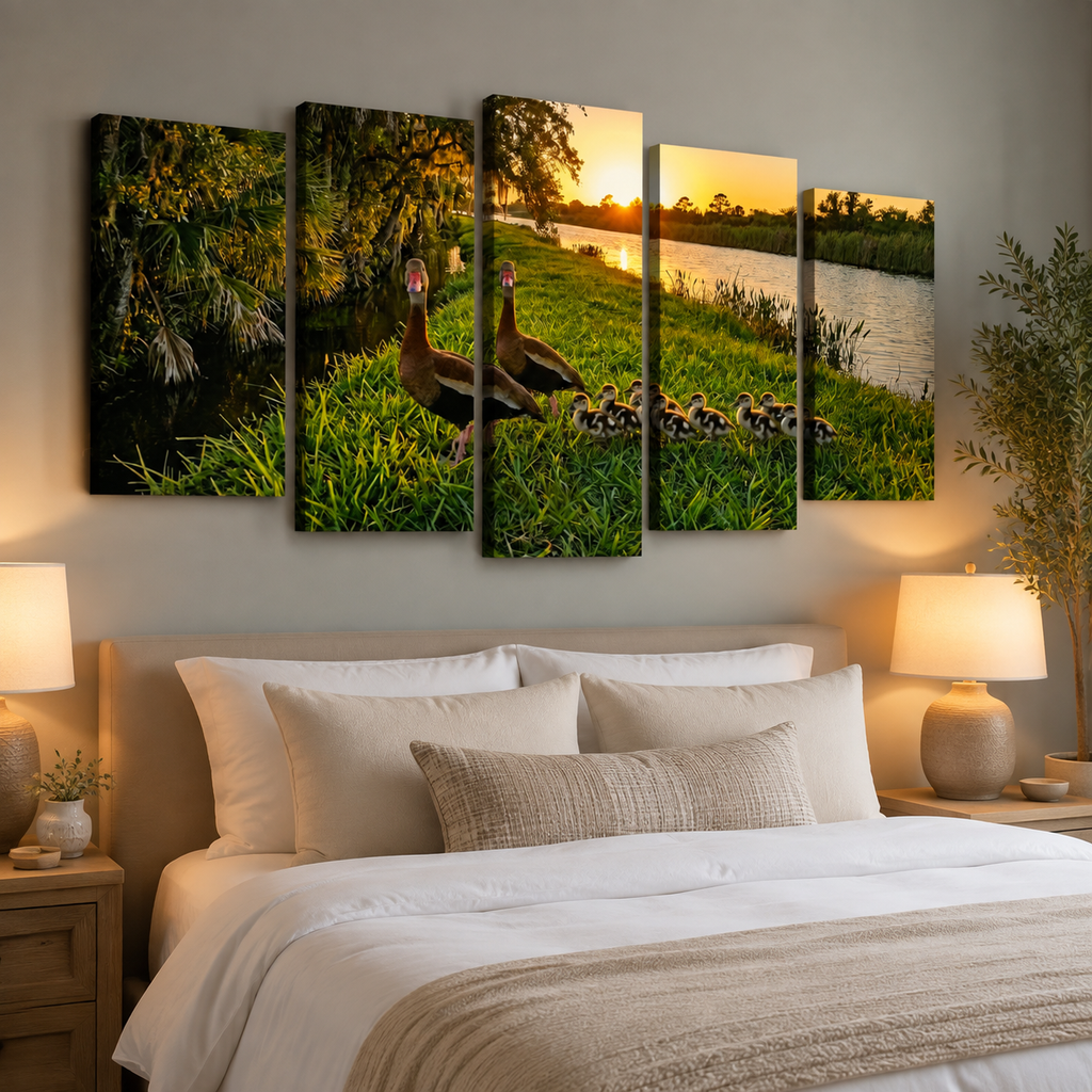 A five-panel canvas wall art set depicting a Black-bellied Whistling-Ducks family at sunset hung above a neatly made bed in a modern bedroom setting.