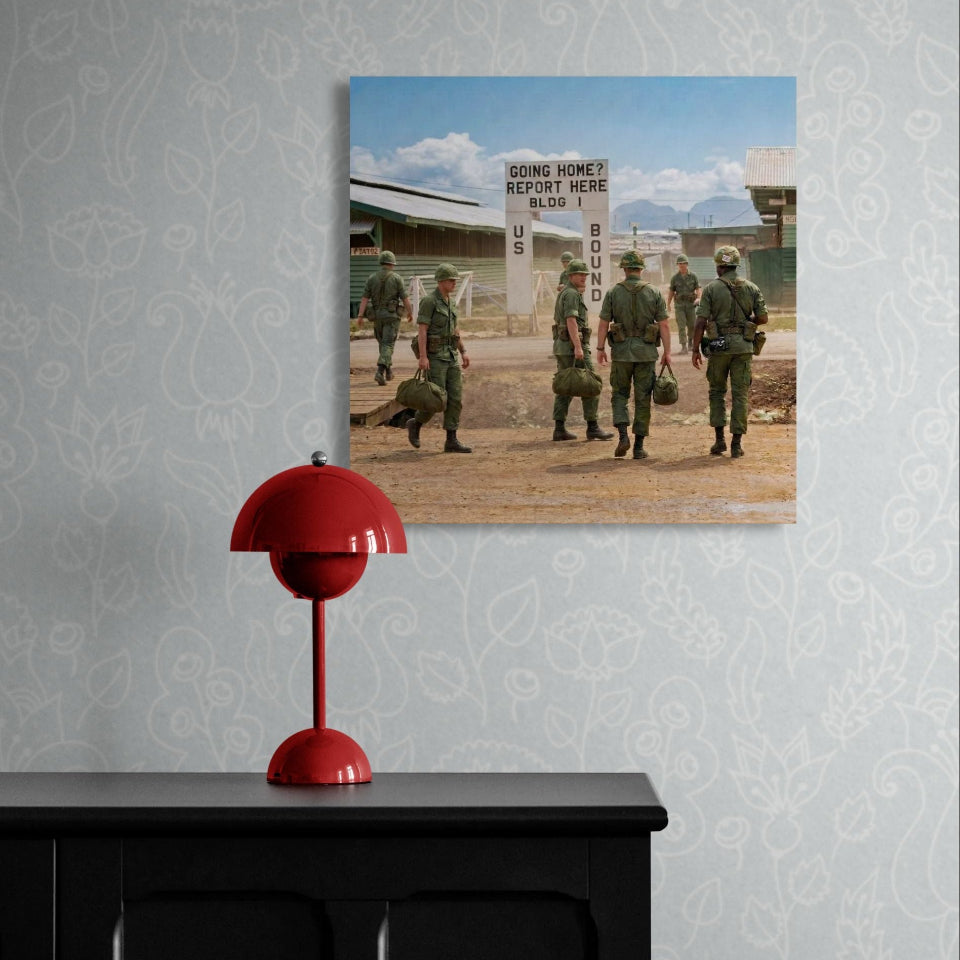 Canvas print of soldiers walking towards a sign on a wall with a red lamp below.