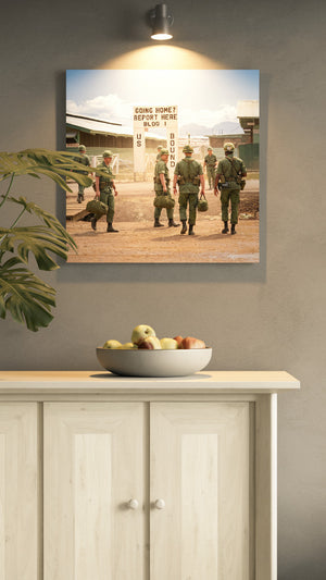 Framed photograph of soldiers on a wall above a wooden cabinet with fruit bowl.