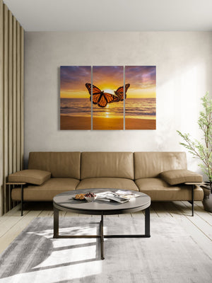 Living room with a large sofa, coffee table, and a triptych artwork of a butterfly over water on the wall.
