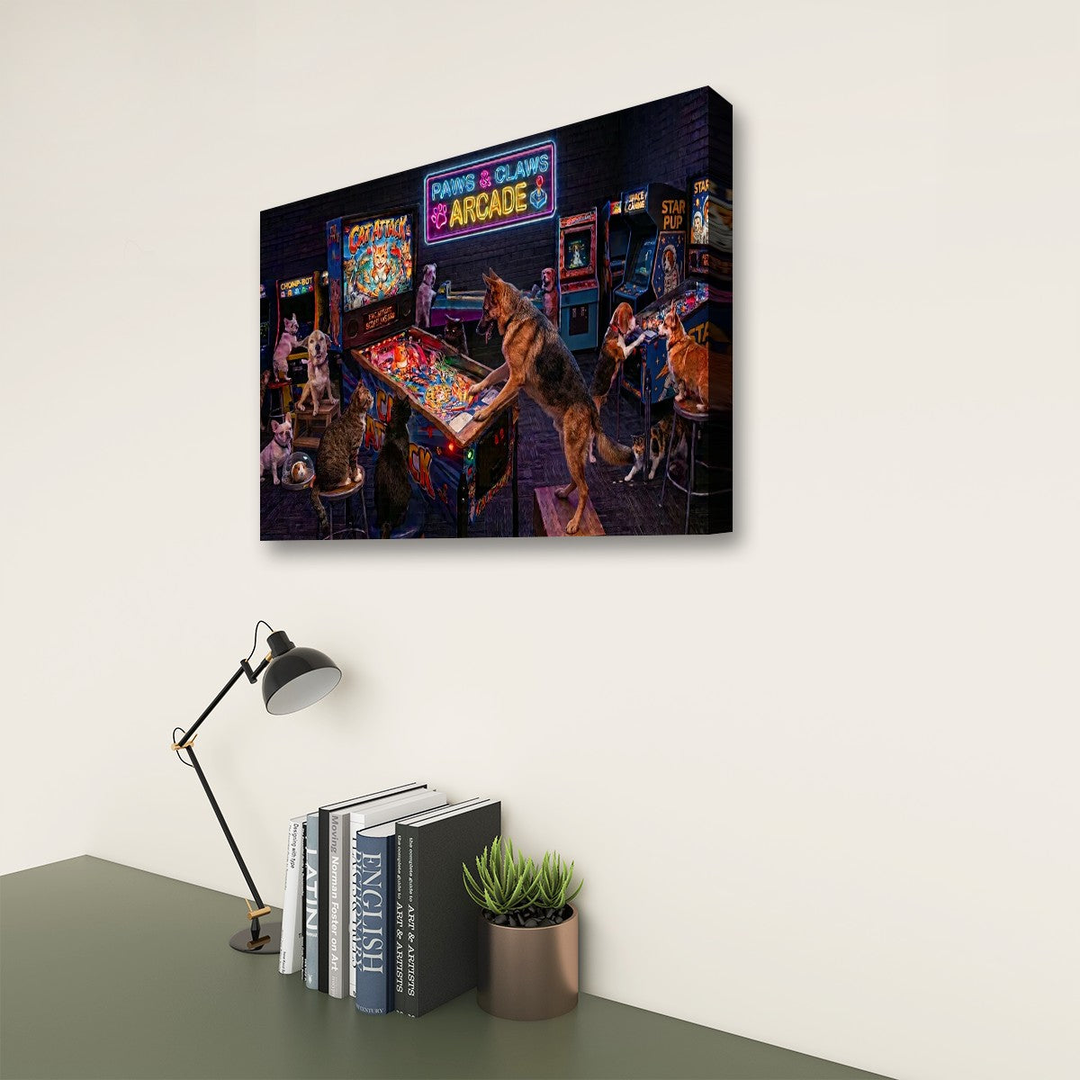 A rectangular wall art print showing a neon-lit arcade scene with a wolf-like character, displayed on a light wall above a desk with a lamp, books, and a small plant.
