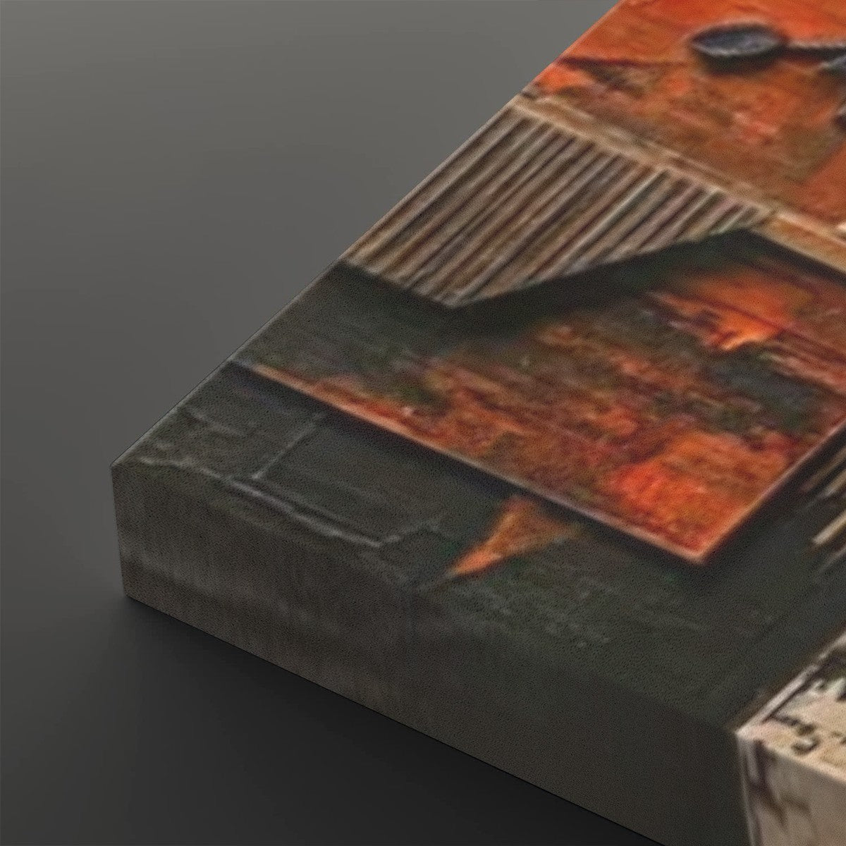 A close-up of a textured canvas print showing an abstract industrial design with rusted orange panels, corrugated metal textures, and dark gray sections, displayed on a dark gray background.