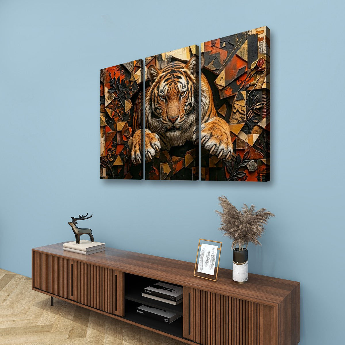 Three-panel canvas wall art featuring a stylized tiger in a geometric abstract design, displayed on a light blue wall above a wooden console table with decorative items.