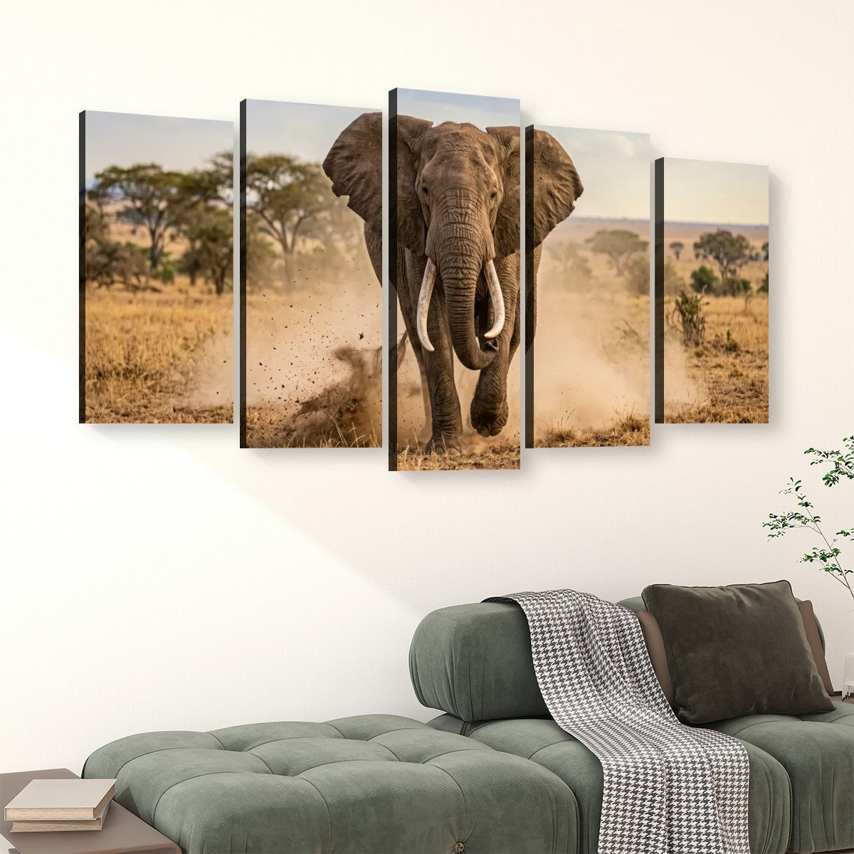 A five-panel canvas wall art set depicting a large elephant walking through a dry savanna landscape, displayed above a green sofa in a modern living room setting.
