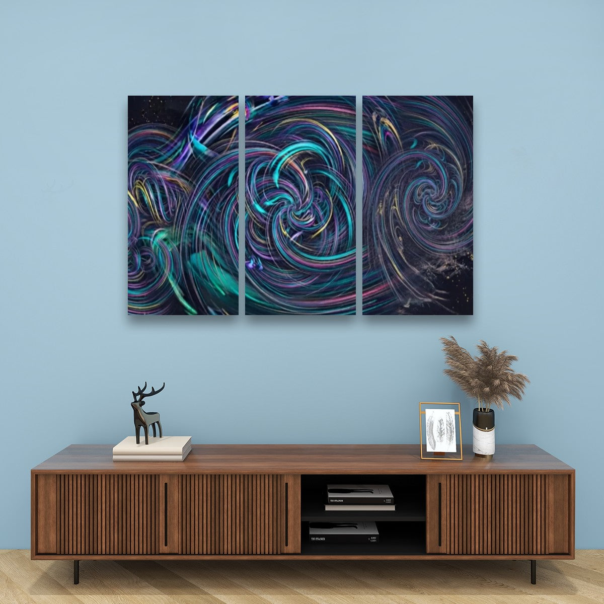 A three-panel abstract wall art set with swirling neon-like patterns in teal, purple, pink, and black, displayed above a wooden media console against a light blue wall.