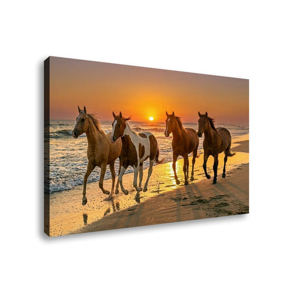 A rectangular canvas wall art print showing four horses running along a beach at sunset, photographed against a plain white background.