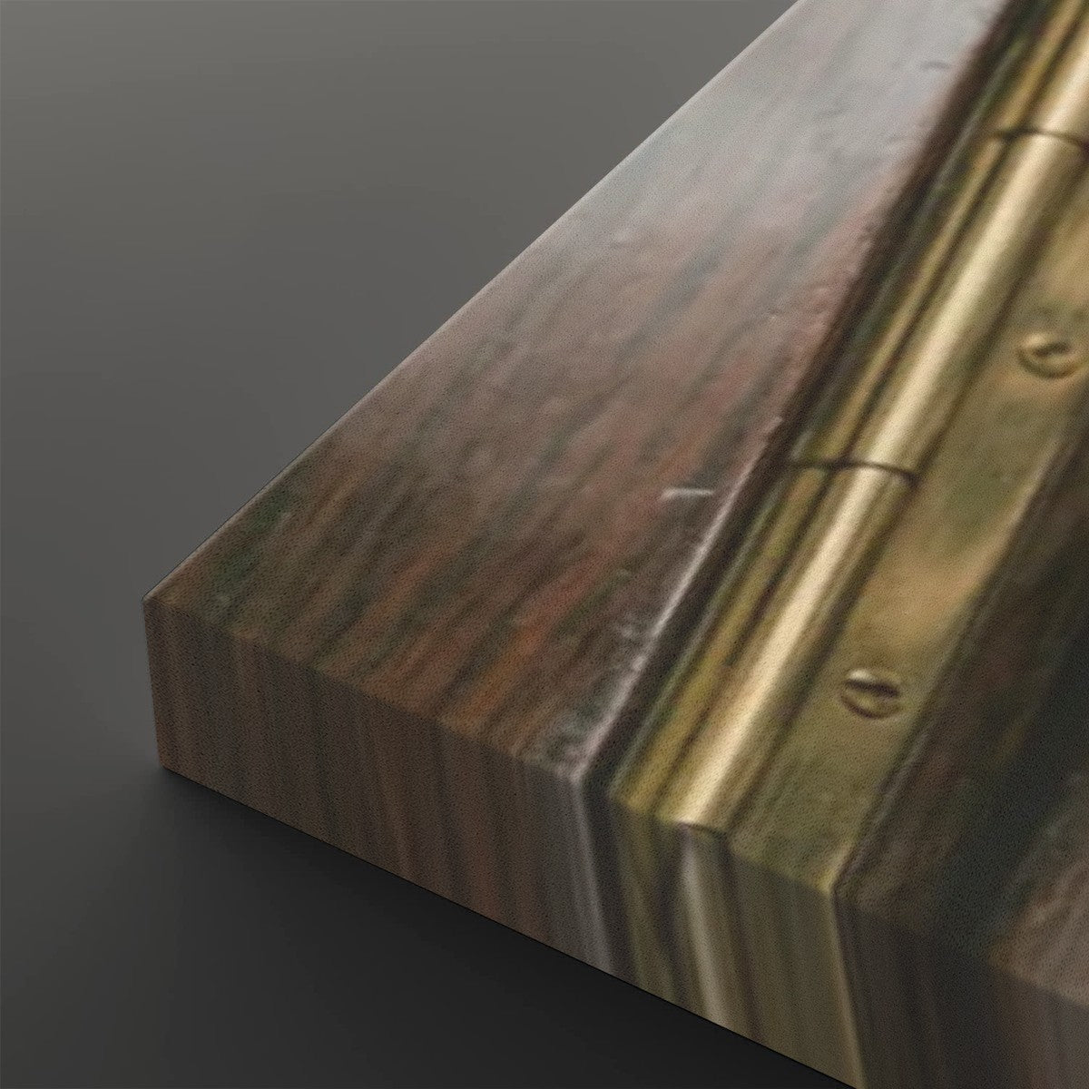 Close-up of a wooden panel or door edge with a warm brown wood grain finish and a brass hinge strip, shown on a dark gray background.