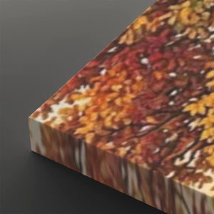 A rectangular canvas or panel with a printed autumn foliage pattern, shown at an angle on a dark gray background. The print features warm fall colors including orange, red, yellow, and brown.