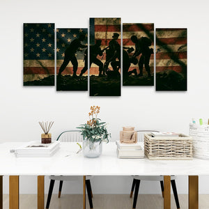 A five-panel canvas wall art set depicting silhouetted soldiers against a distressed American flag, displayed above a white table in a modern room setting.