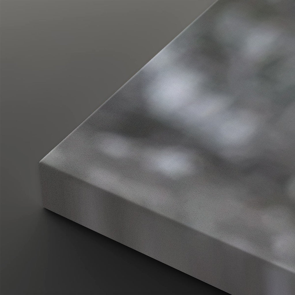 A close-up of a brushed silver metal panel or slab corner, showing a matte metallic texture and smooth beveled edge against a dark gray background.