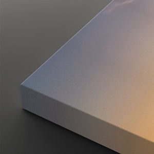 A close-up of a matte white rectangular panel or book corner, showing its textured surface and depth against a dark gray background.