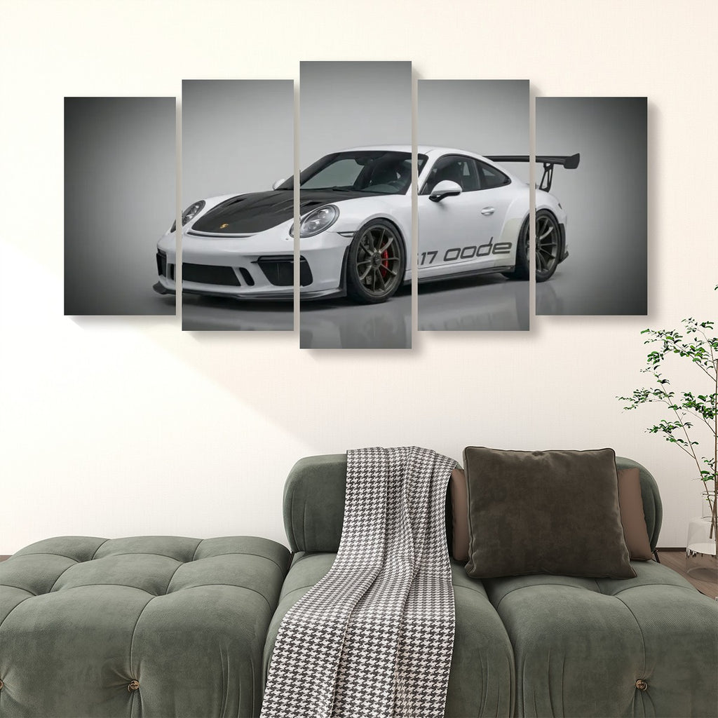 A five-panel canvas wall art set depicting a white Porsche 911 'Code White' sports car, displayed in a modern living room setting above a green tufted sofa.