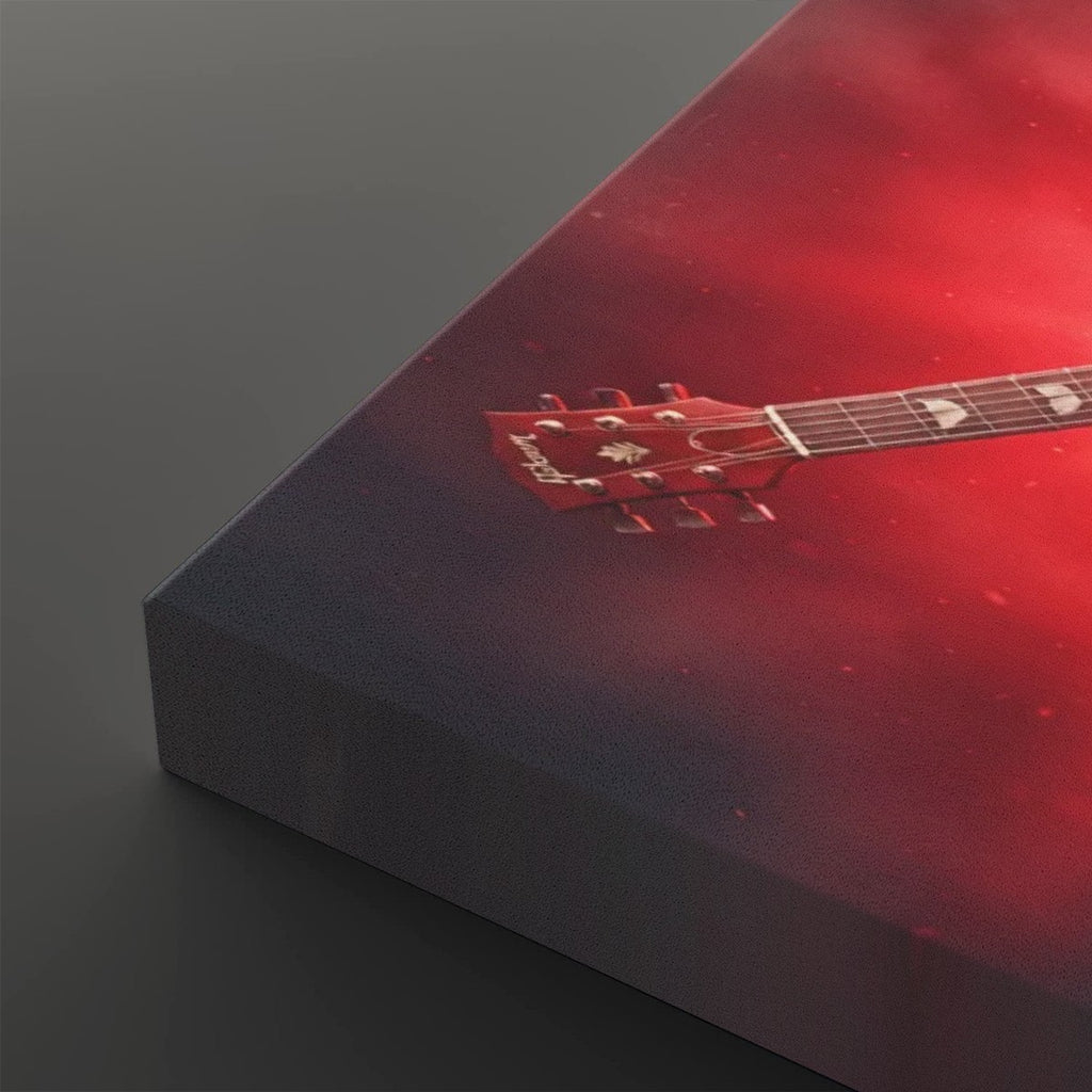 A close-up of a rectangular canvas or print showing a red acoustic guitar headstock and neck against a smoky red and dark gray background, photographed on a dark gray surface.