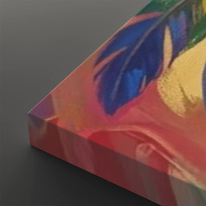 A close-up angled view of a colorful abstract artwork or canvas print showing a blue feather motif over pink, red, orange, and gold tones on a dark gray background.