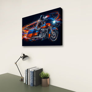 A rectangular wall art print showing a stylized blue and orange Road Glide type motorcycle with glowing light trails, displayed above a desk with a lamp, books, and a small plant against a light wall.