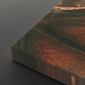 A close-up of a rectangular panel or tile with a marbled abstract pattern in earthy tones, shown at an angle on a dark gray background.