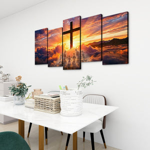 A 5-panel canvas wall art set depicting a dramatic sunset sky with a large cross silhouette, displayed on a white wall above a dining table in a modern room setting.
