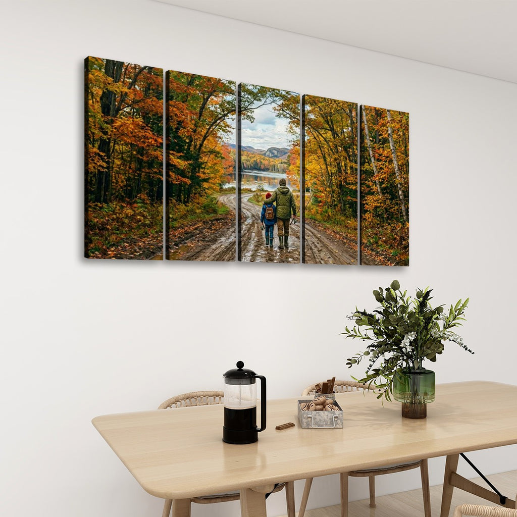 A five-panel canvas wall art set depicting a couple walking on a dirt road through an autumn forest, displayed on a white wall above a light wood dining table with a vase of greenery and a French press.