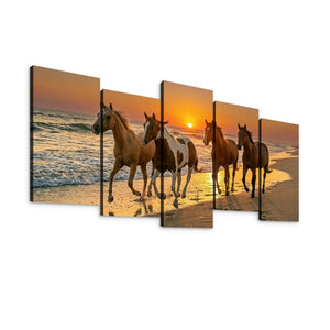 Five-panel canvas wall art showing four horses walking on a beach at sunset, displayed against a plain white background.
