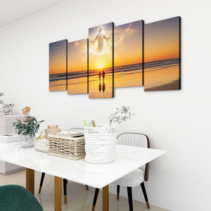 A five-panel canvas wall art set depicting Jesus standing on a beach at sunset with two small figures in the foreground, displayed on a white wall above a dining table in a modern room.
