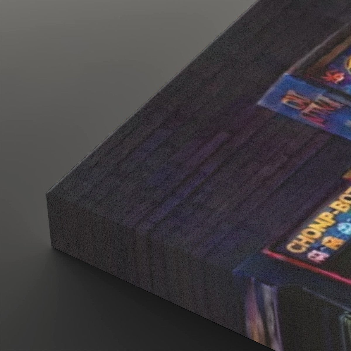 A close-up of a dark rectangular product, likely a book, box, or panel, showing a textured dark gray surface with a colorful printed label in the corner that reads 'CHAMPIONSHIP'.