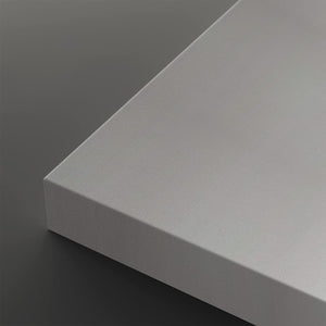 A close-up of a light gray rectangular panel or board corner, shown against a dark gray background.