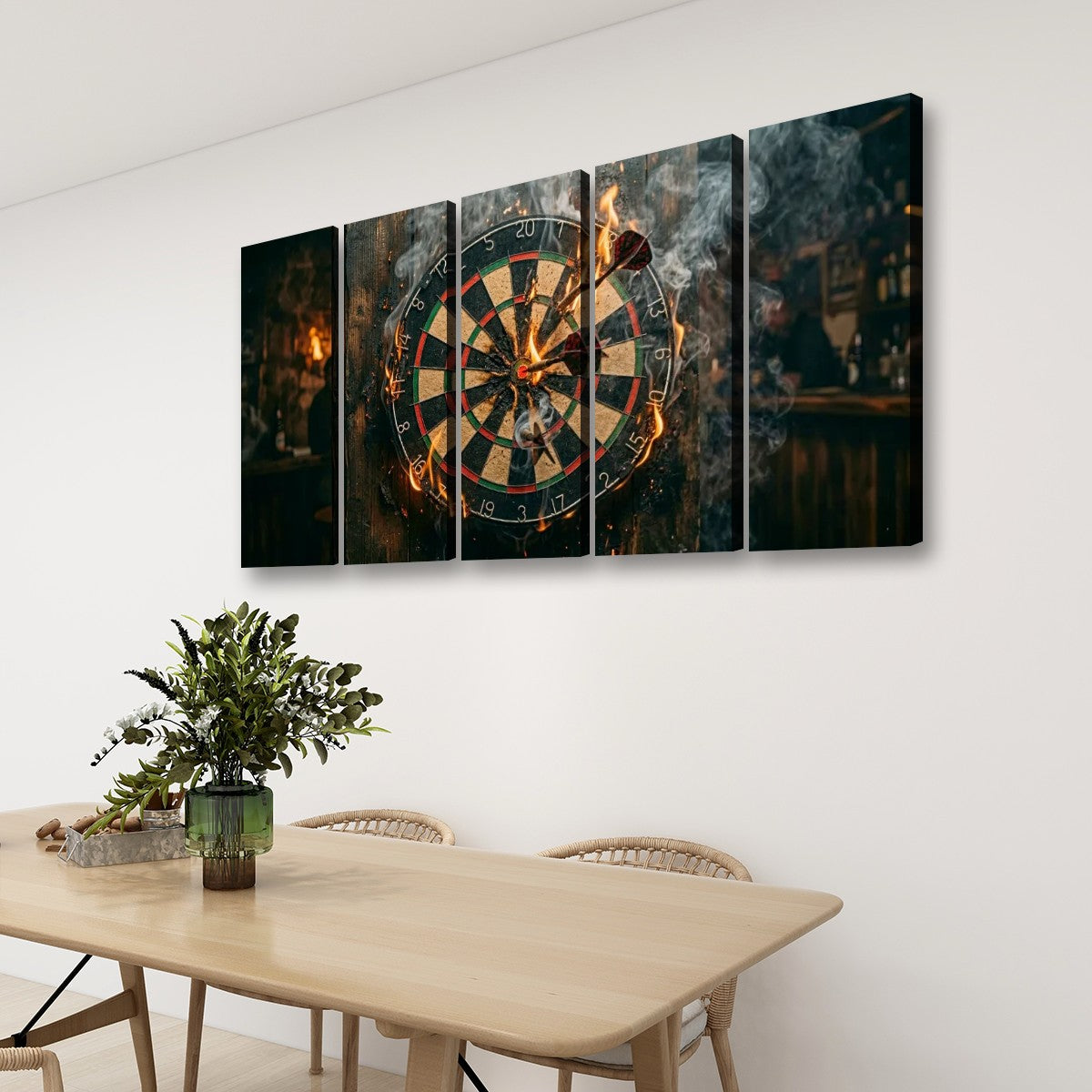 A four-panel canvas wall art set depicting a burning dartboard in a dimly lit bar, displayed on a white wall above a wooden dining table with chairs and a potted plant.