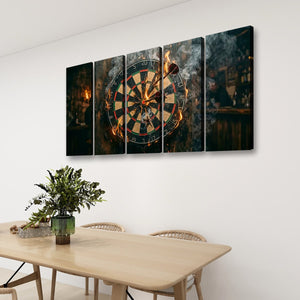 A four-panel canvas wall art set depicting a burning dartboard in a dimly lit bar, displayed on a white wall above a wooden dining table with chairs and a potted plant.