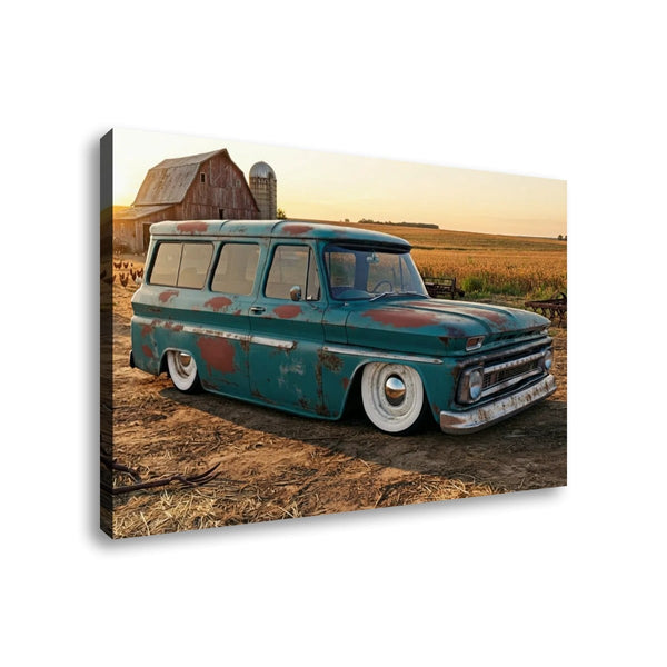 A rectangular canvas wall art print showing a vintage teal 1966 Chevy Suburban Carryall  parked on dirt near a barn and fields at sunset, photographed against a plain white background.