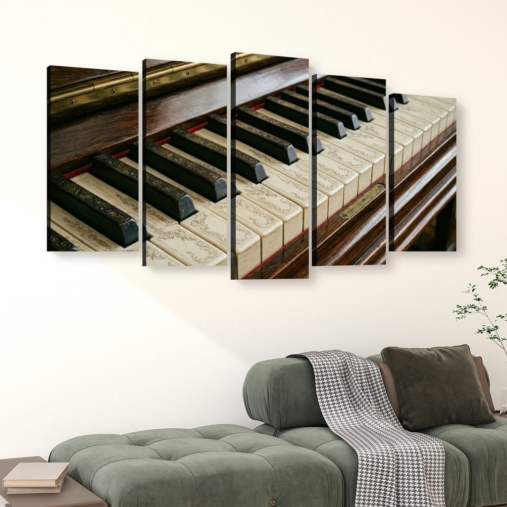 A five-panel canvas wall art set depicting a close-up of piano keys and wooden piano structure, displayed above a green sofa in a living room setting.