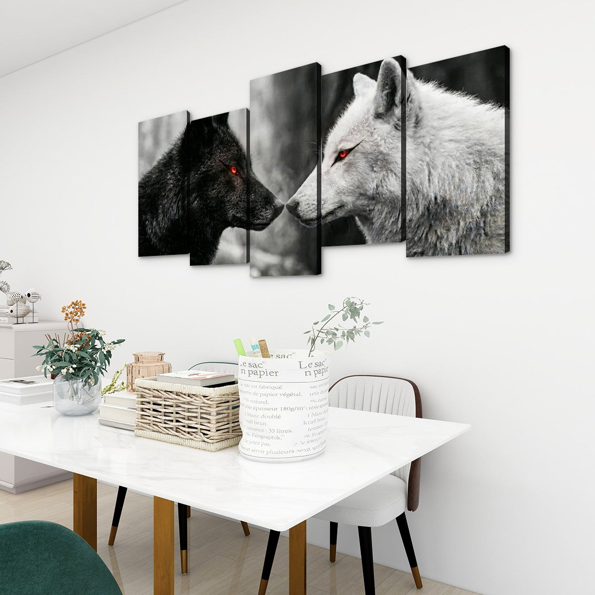 A 5-panel canvas wall art set depicting a black wolf and a white wolf facing each other, displayed on a white wall above a dining table in a modern room setting.