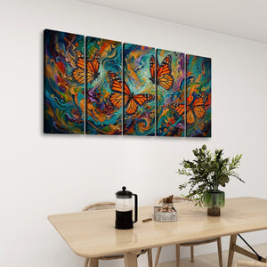 A four-panel canvas wall art set featuring vibrant painted monarch butterflies over swirling teal, blue, orange, and purple abstract backgrounds, displayed on a white wall above a dining table with chairs, a French press, and a plant.