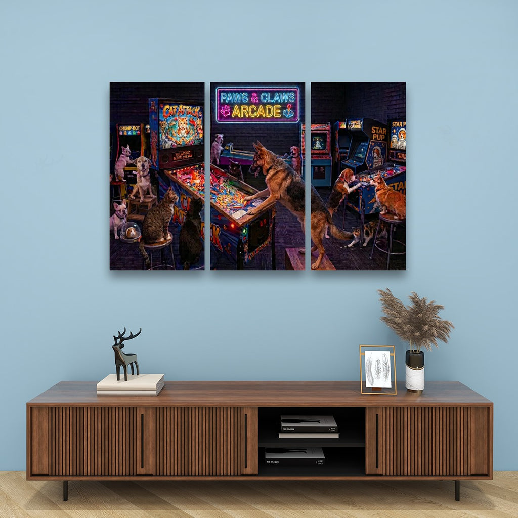A three-panel canvas wall art print depicting dogs playing arcade games in a retro arcade, displayed on a light blue wall above a wooden console table.