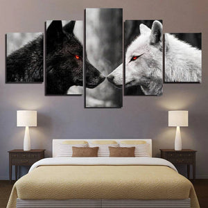 Five-panel wall art of black and white wolves with red eyes in a bedroom setting.