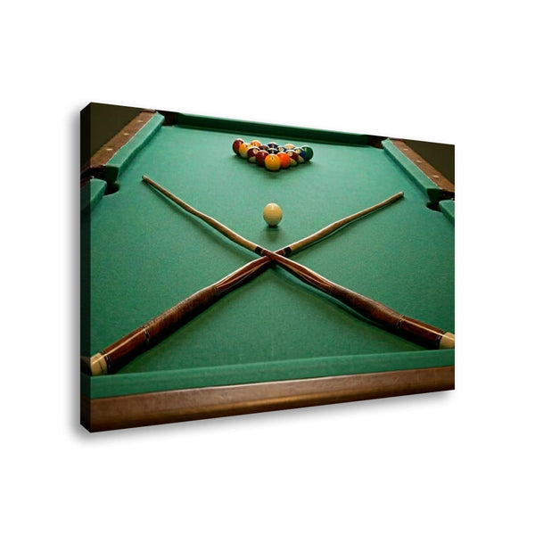 A rectangular wall art print or canvas showing a green pool table with crossed pool sticks, a white cue ball, and a cluster of colored balls near the top, photographed against a light gray background.