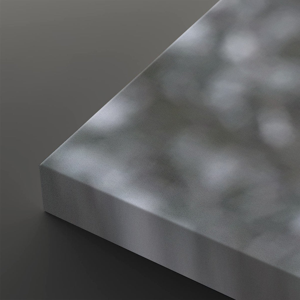 A close-up of a rectangular metallic panel or board with a brushed silver finish, shown at an angle against a dark gray background.