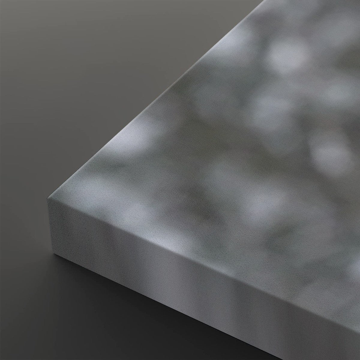 A close-up of a rectangular metallic panel or board with a brushed silver finish, shown at an angle against a dark gray background.