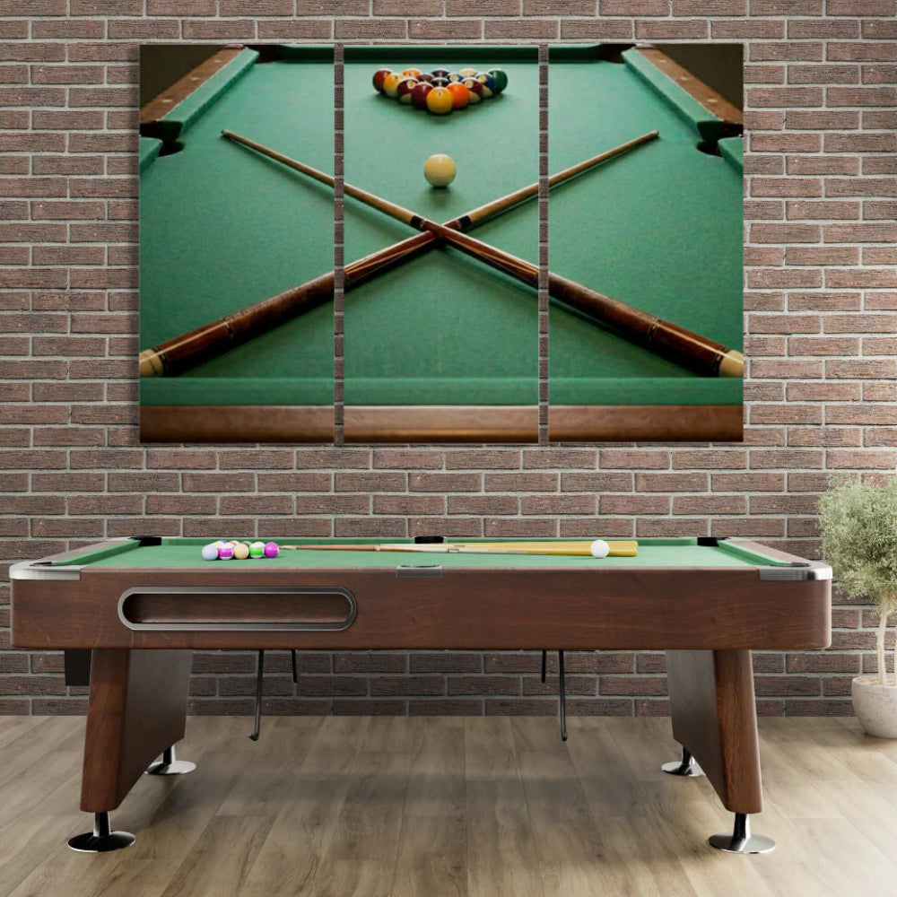 Pool table with pool cues and balls against a brick wall