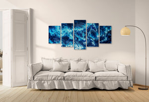 Five blue abstract horse paintings on a wall above a white sofa.