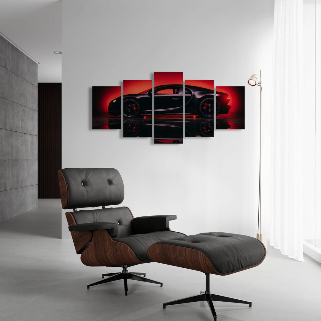 A modern living room setting featuring a multi-panel canvas wall art print of a black Bugatti Chiron sports car against a red background, displayed above a black leather and wood lounge chair with an ottoman.