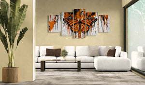 Living room with a white sofa, coffee table, and Monarch butterfly-themed wall art.