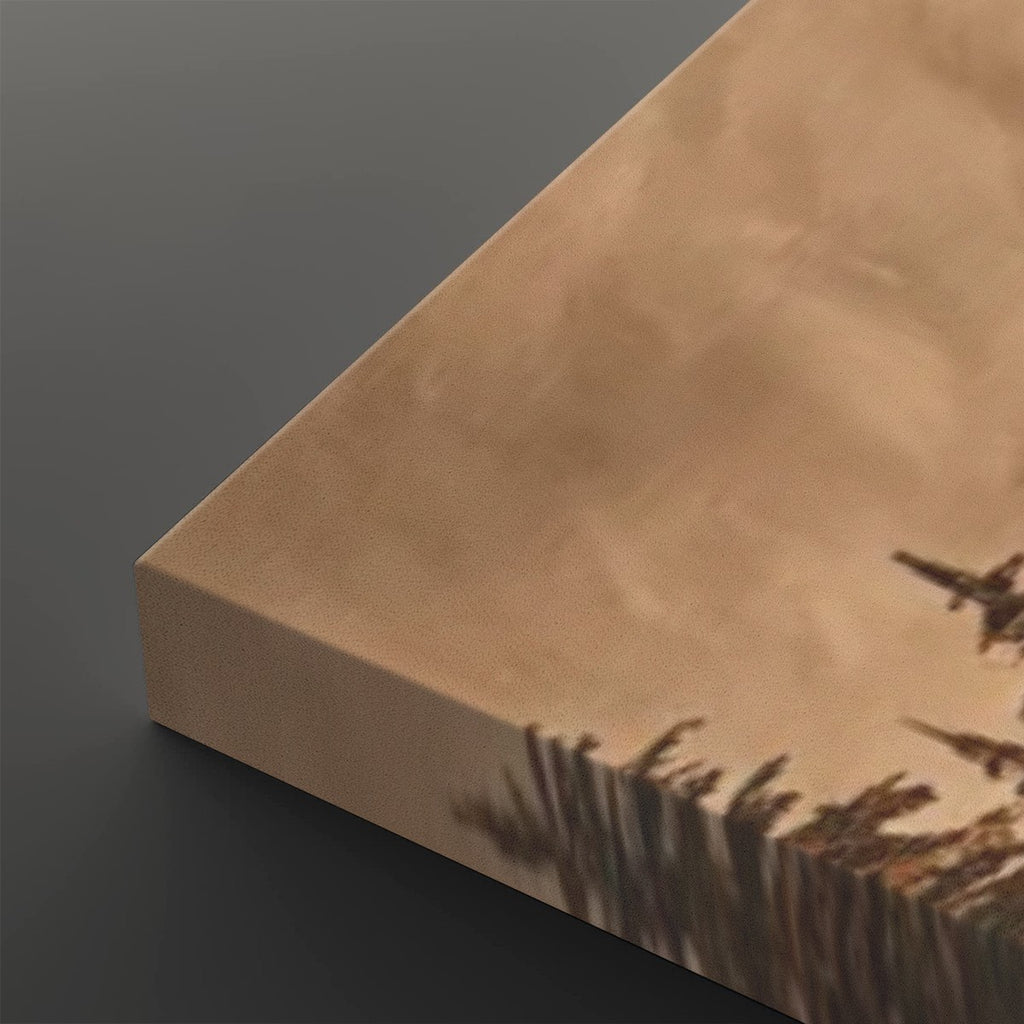 A close-up of a canvas print showing its wrapped edge, featuring a sepia-toned landscape with tall grasses and jet airplanes flying across a cloudy sky.