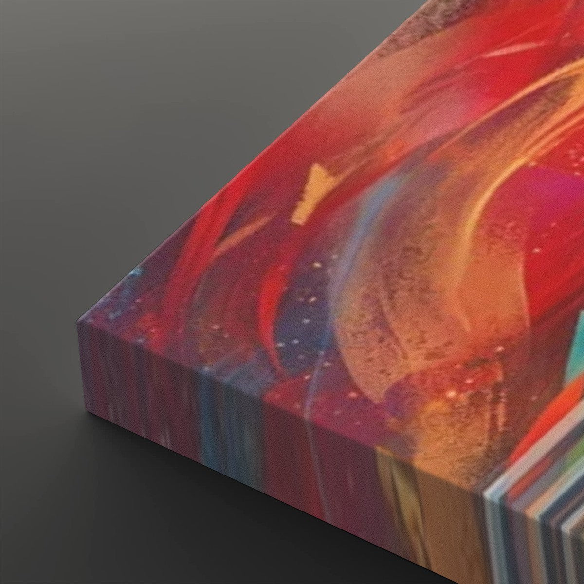 Abstract canvas wall art with swirling red, orange, pink, blue, and gold brushstrokes, shown at an angle on a dark gray background.